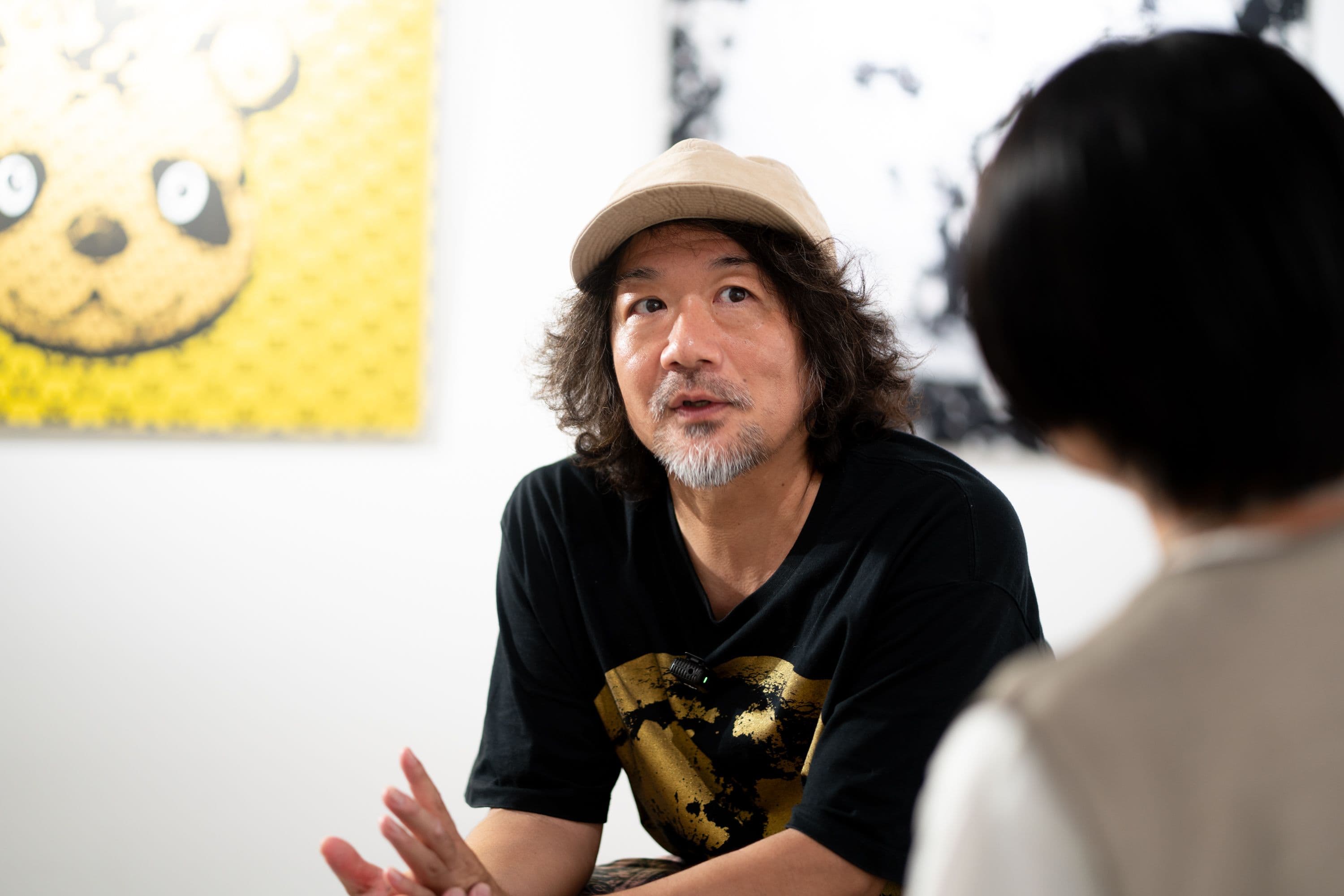パンダの作品を背に、身ぶりを交えて話す池城安武さん